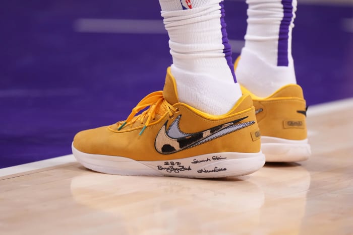 View of orange and white Nike LeBron 20 shoes.